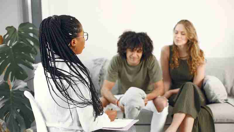 A couple at a therapy session discussing issues with a professional counselor., tags: terapisti - pexel