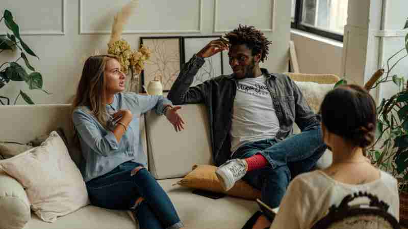 A couple is engaged in a lively conversation during a therapy session with a counselor., tags: le coppie - pexel