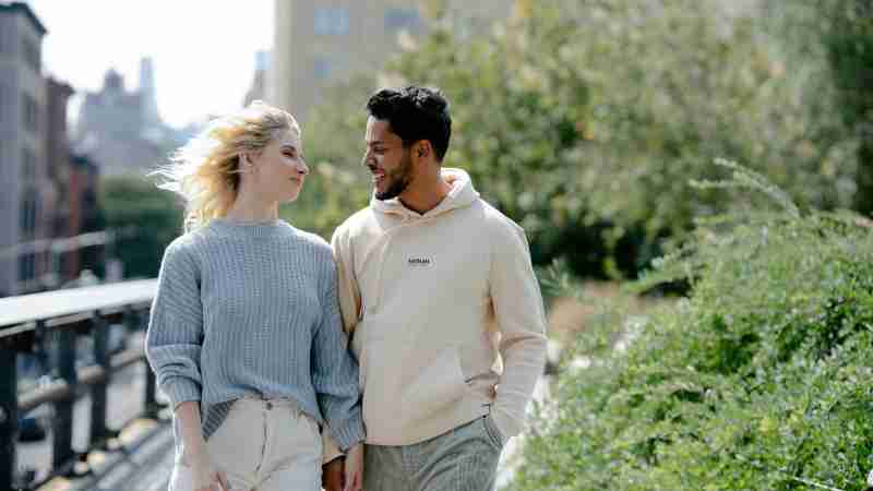Cheerful couple holding hands and walking together through an urban park on a sunny day., tags: terapia di - pexel