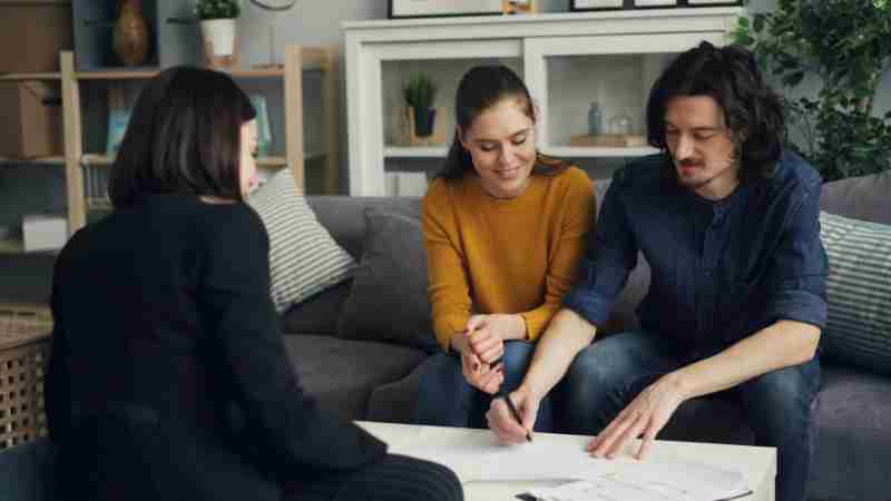 Three young adults working together at a home setting, signing documents., tags: la relazioni - pexel